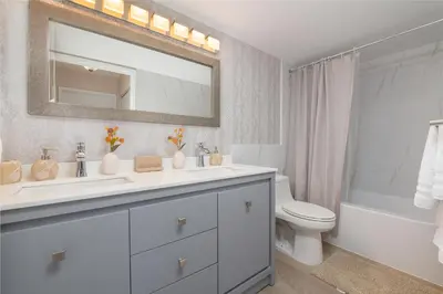 a bathroom with a sink and a toilet and a mirror at Spacious 3 Bedroom Condo in Aventura in Aventura