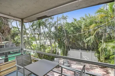 a balcony with a table and chairs and trees at By Hard Rock Guitar Hotel casino 7 min walk in Dania Beach