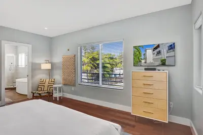 a bedroom with a bed and a dresser and a bathroom at Victoria Park Overlook in Fort Lauderdale