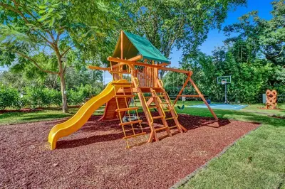 a playground with a slide in a park at Family villa w heated pool gameroom fire pit in Davie