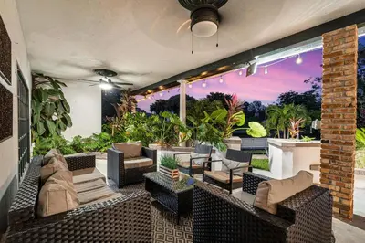 an outdoor patio with couches and chairs and plants at Family villa w heated pool gameroom fire pit in Davie
