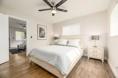 a white bedroom with a bed and a ceiling fan at The Guesthouse 1 - Wilton Manors in Fort Lauderdale