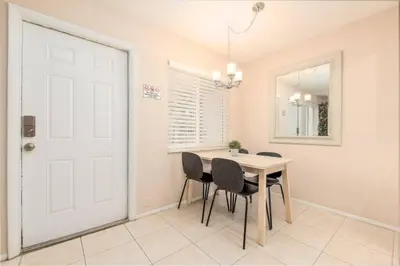 a dining room with a table and chairs and a white door at The Retreat 3 - Wilton Manors in Fort Lauderdale