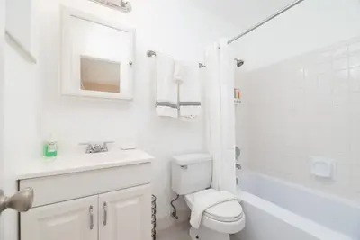 a white bathroom with a toilet and a sink at The Retreat 2 - Wilton Manors in Fort Lauderdale
