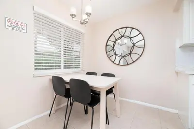 a dining room with a table and chairs and a mirror at The Retreat 1 - Wilton Manors in Fort Lauderdale