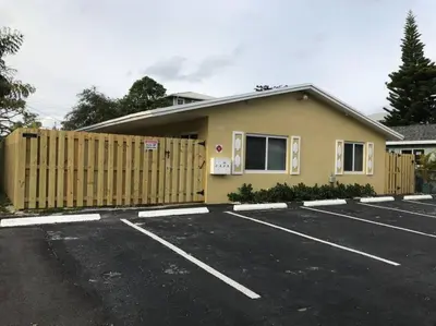 a building with a fence in a parking lot at The Retreat 1 - Wilton Manors in Fort Lauderdale