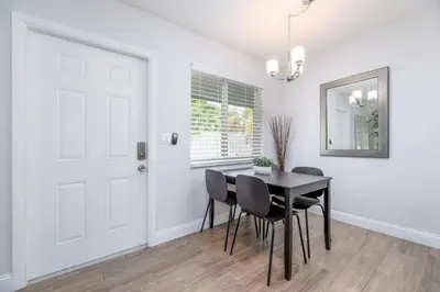 a dining room with a table and chairs and a white door at The Guesthouse 2 - Wilton Manors in Fort Lauderdale