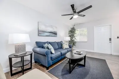 a living room with a blue couch and a ceiling fan at The Guesthouse 2 - Wilton Manors in Fort Lauderdale