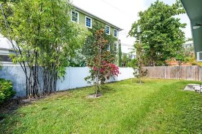 a yard with two trees and a fence at The Guesthouse 3 - Wilton Manors in Fort Lauderdale