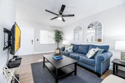 a living room with a blue couch and a tv at The Guesthouse 3 - Wilton Manors in Fort Lauderdale