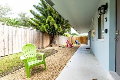 a yard with two green chairs and a fence at The Guesthouse 3 - Wilton Manors in Fort Lauderdale