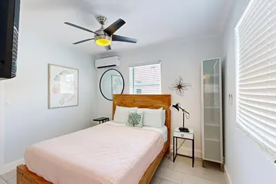 a bedroom with a bed and a ceiling fan at Pastel Dream in Hollywood