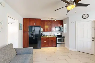 a kitchen with a black refrigerator and wooden cabinets at Pastel Dream in Hollywood