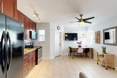 a kitchen with a black refrigerator and a table at Pastel Dream in Hollywood