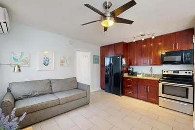 a living room with a couch and a black refrigerator at Pastel Dream in Hollywood