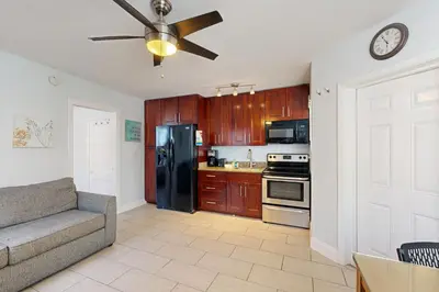 a kitchen with a couch and a black refrigerator at Pastel Dream in Hollywood