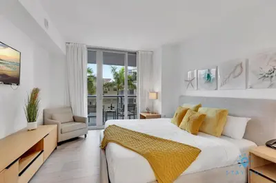 a white bedroom with a large bed and a window at Modern Resort - Gym - Pool - Near Beach in Hallandale Beach
