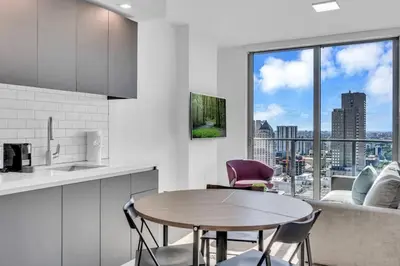 a kitchen with a table and chairs and a large window at Modern 1 Bed Condo across from Bayside in Downtown in Miami