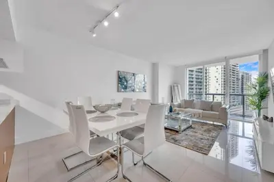 a white dining room with a white table and chairs at Modern 1 Bed ICON Brickell with Amazing Views in Miami
