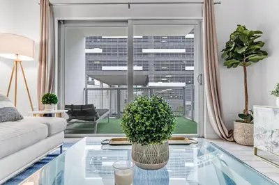 a living room with a couch and a glass table at Lovely Unit Mins from Wynwood with Free Parking in Miami