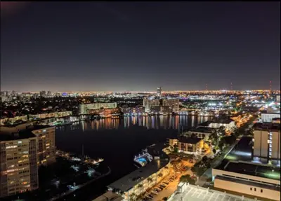 a view of a city at night with the water at Relax by the Sea in This Cozy Beachfront Room 908B in Hallandale Beach