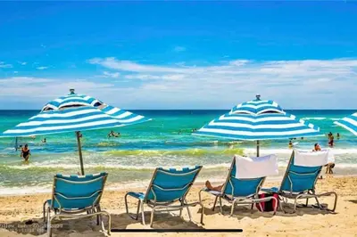 a group of chairs and umbrellas on a beach at Relax by the Sea in This Cozy Beachfront Room 908B in Hallandale Beach
