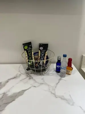 a basket of snacks and bottles on a marble counter at Stunning Deluxe Studio in Hialeah