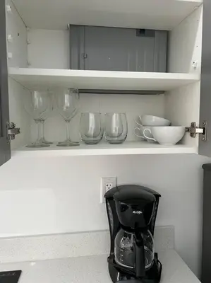 a kitchen shelf with wine glasses and a blender at Stunning Deluxe Studio in Hialeah