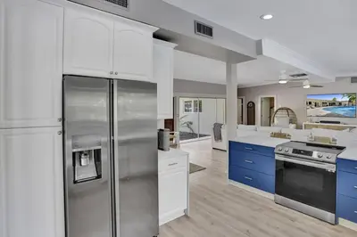 a kitchen with stainless steel appliances and blue cabinets at Brand New! Heated Pool, Golf Cart, Next to Beach in Fort Lauderdale