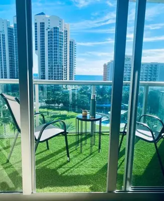 a balcony with two chairs and a table on the grass at Ocean Reserve Piso 9 - STR 2412 in Miami Beach