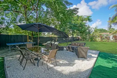a patio with a table with an umbrella and chairs at River House 4BR, Pool/Hot Tub in Miami