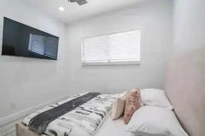 a bedroom with a bed and a flat screen tv at New Townhome near Wilton/Las Olas/Beach in Fort Lauderdale