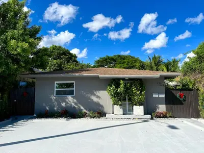 a small house with a driveway at Beautiful, fully furnished 2bed 1bath house - 5 minute walk to Miracle Mile Downtown Coral Gables in Miami