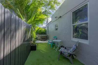 a patio with chairs and a table and a fence at Beautiful, fully furnished 2bed 1bath house - 5 minute walk to Miracle Mile Downtown Coral Gables in Miami