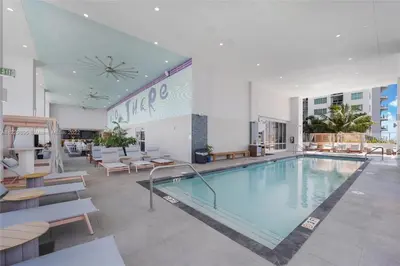 a large swimming pool in a building with tables and chairs at - Casiola Studio's - near Cruise Terminal, Bayfront Park and Kaseya Center in Miami