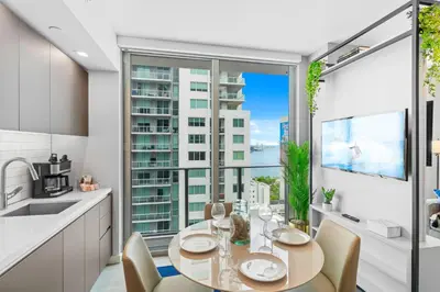 a kitchen with a table and chairs and a large window at - Casiola Studio's - near Cruise Terminal, Bayfront Park and Kaseya Center in Miami