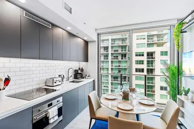 a kitchen with a table and chairs and a large window at - Casiola Studio's - near Cruise Terminal, Bayfront Park and Kaseya Center in Miami