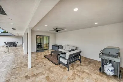 a living room with a ceiling fan and a piano at Sandals Beach Cottage in Fort Lauderdale