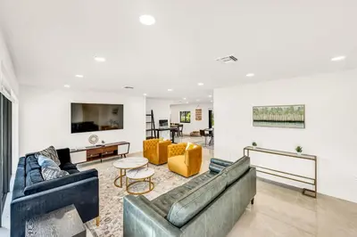 a living room with two couches and a table at Sandals Beach Cottage in Fort Lauderdale