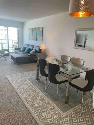 a living room with a glass table and chairs at Ocean reserve 702 - STR 2315 in Miami Beach