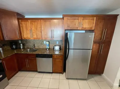 a kitchen with wooden cabinets and a stainless steel refrigerator at Ocean reserve 702 - STR 2315 in Miami Beach