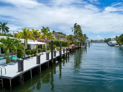a canal with houses and palm trees and water at Casa Flamingo Intracoastal Front with Heated Pool in Fort Lauderdale