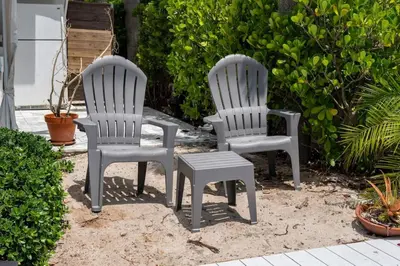 two white chairs and a stool in a yard at Casa Flamingo Intracoastal Front with Heated Pool in Fort Lauderdale