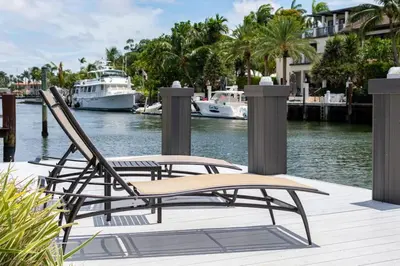 a chair on a dock with boats in the water at Casa Flamingo Intracoastal Front with Heated Pool in Fort Lauderdale