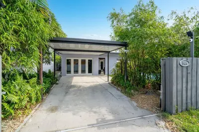a driveway leading to a white building with a garage at Hollys Hacienda with Heated Pool and Patio Area in Hollywood