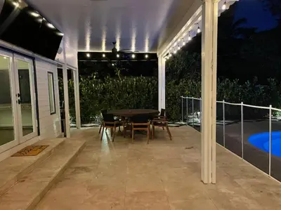 a patio with a table and chairs and lights at Victoria Park Oasis with Heated Pool and More in Fort Lauderdale