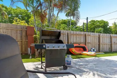 a barbecue grill in a backyard with a playground at Wileys Paradise Three Bedroom Two Bath plus Office and Heated Pool in Hollywood