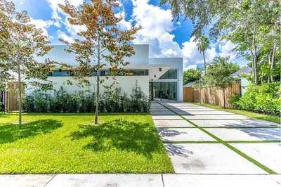 a contemporary home with a concrete driveway and grass at Lux Villa with Pool, Wynwood House by RoveTravel in Miami