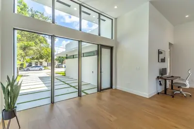 an open living room with glass doors and a desk at Lux Villa with Pool, Wynwood House by RoveTravel in Miami