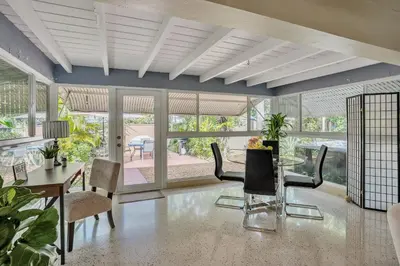 a dining room with a table and chairs and windows at Beautiful Comfy Home With Private Hot Tub Close To Beach home in Fort Lauderdale